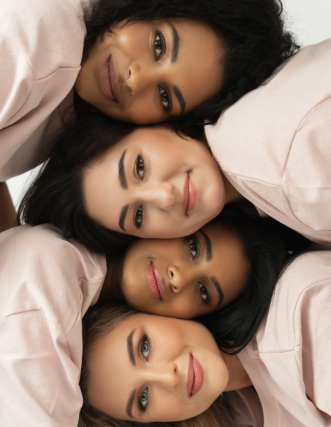 Four happy women with flawless skin posing